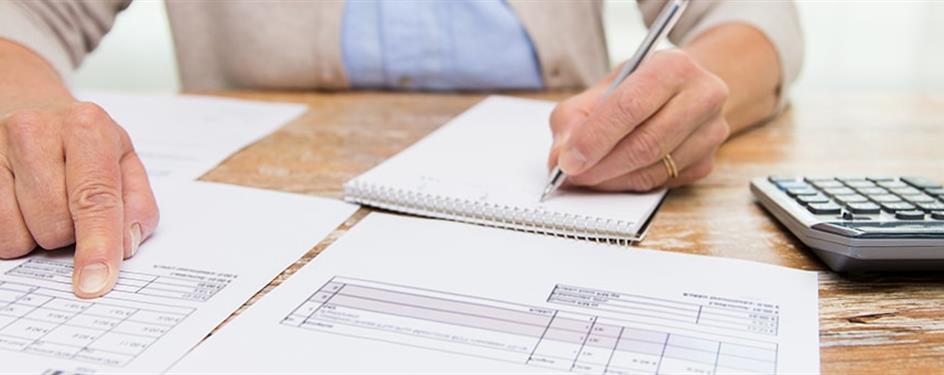 photo of a person looking at some bills on their table